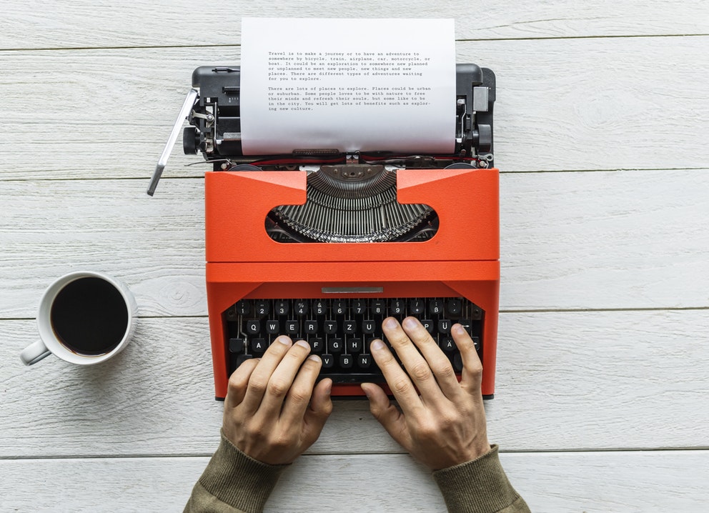 a man typing on typewriter keyboard