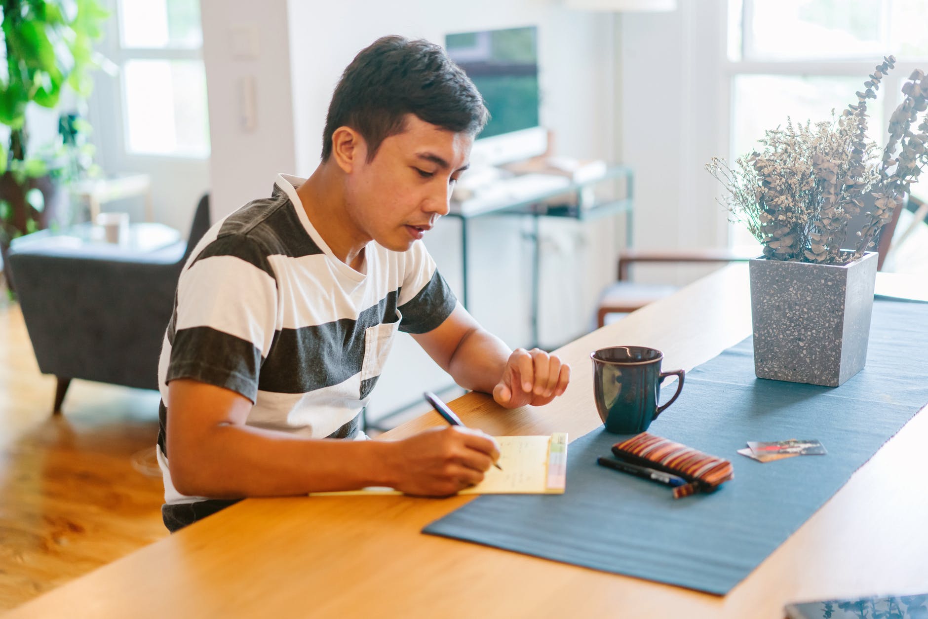 a student writing a grant request letter sitting at the desk