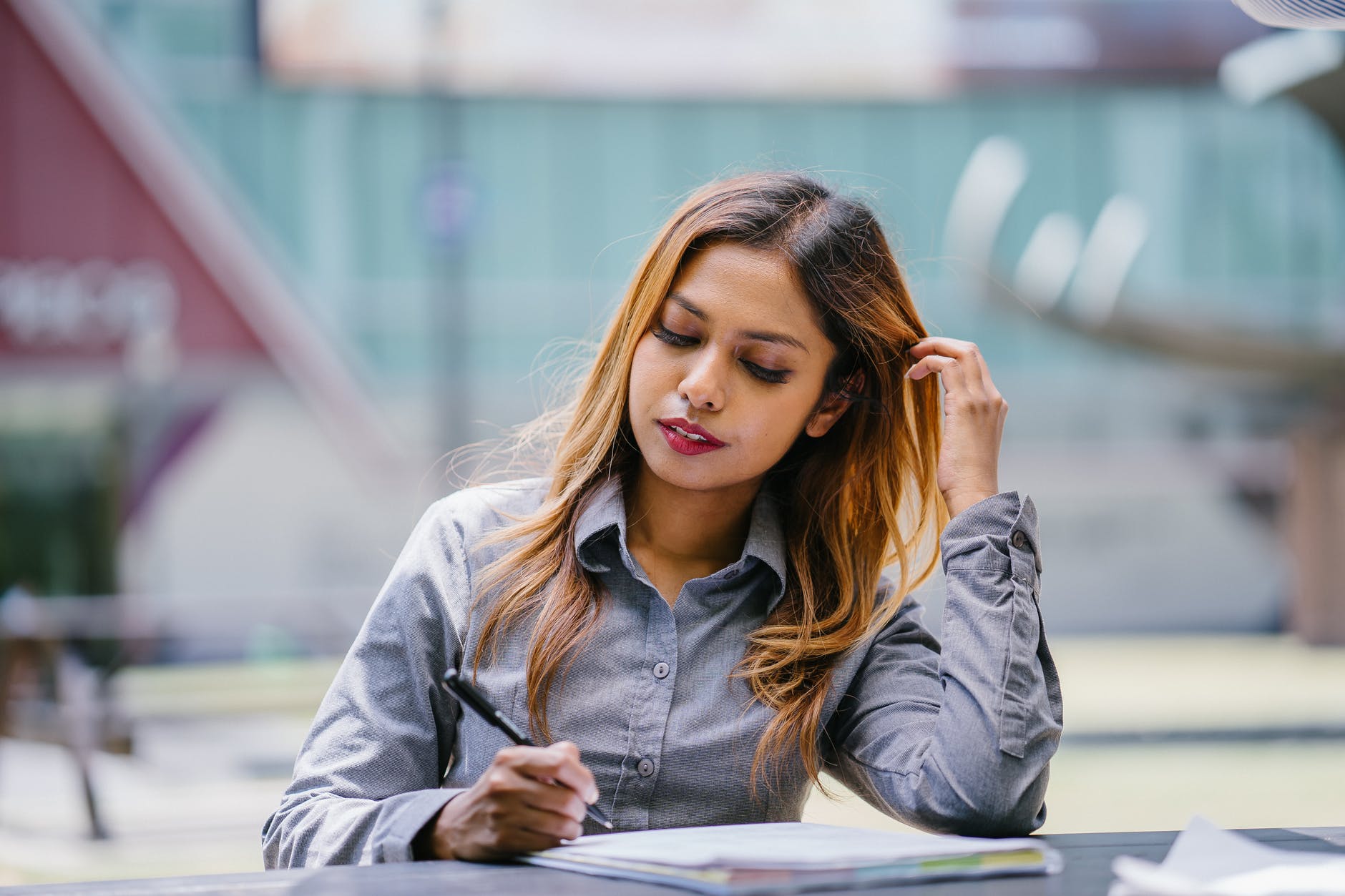 a girl is writing something on a piece of paper