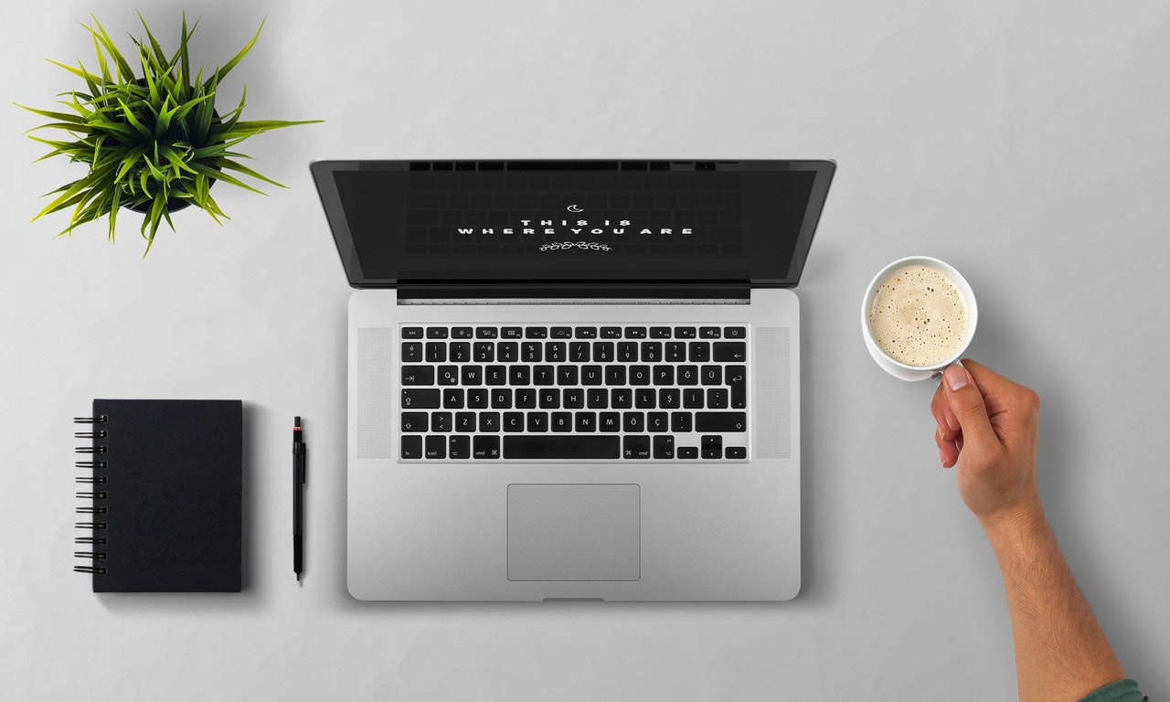 a laptop and a cup of coffe on a desk