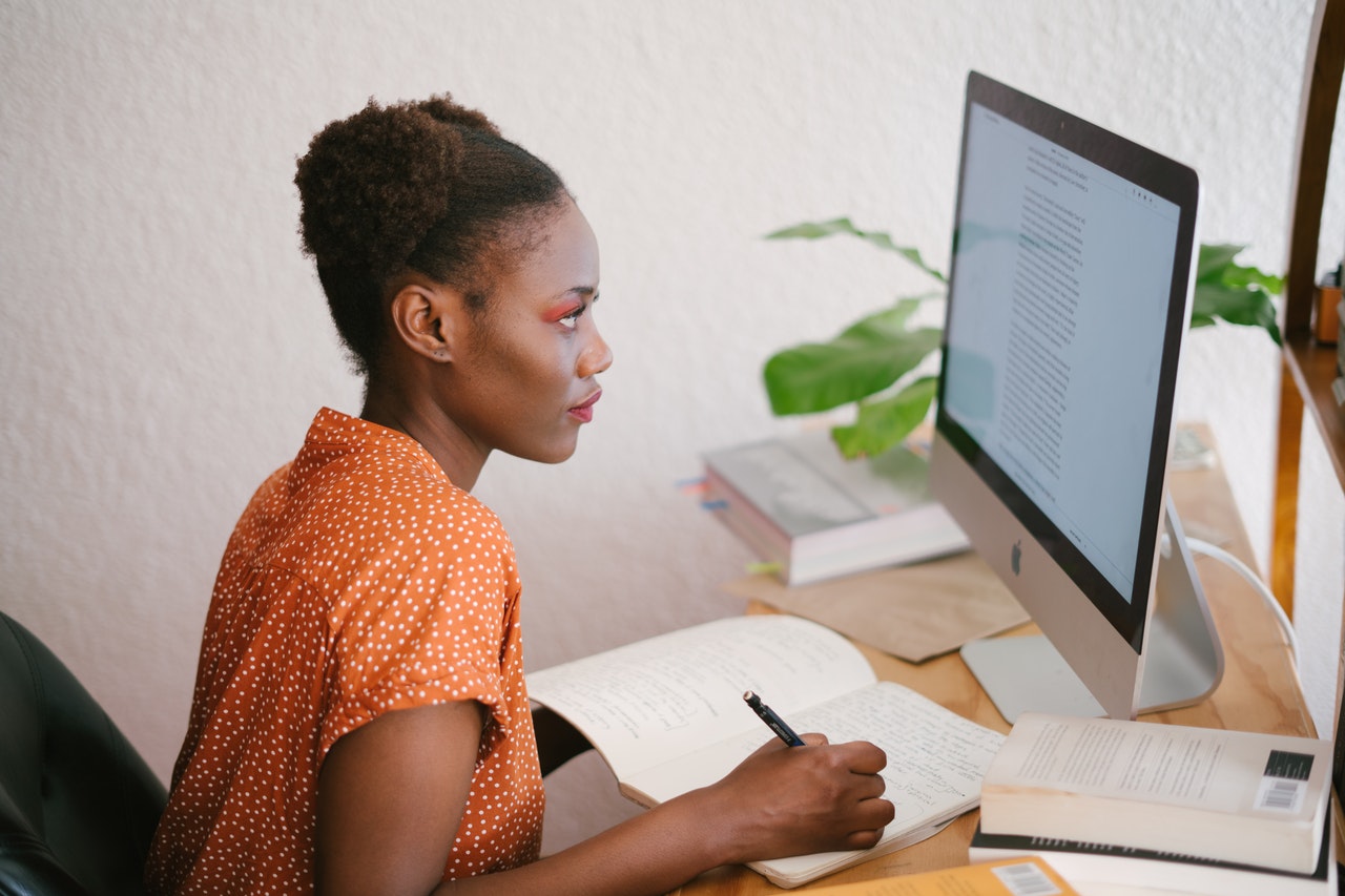 a girl is sitting in front of her computer screen