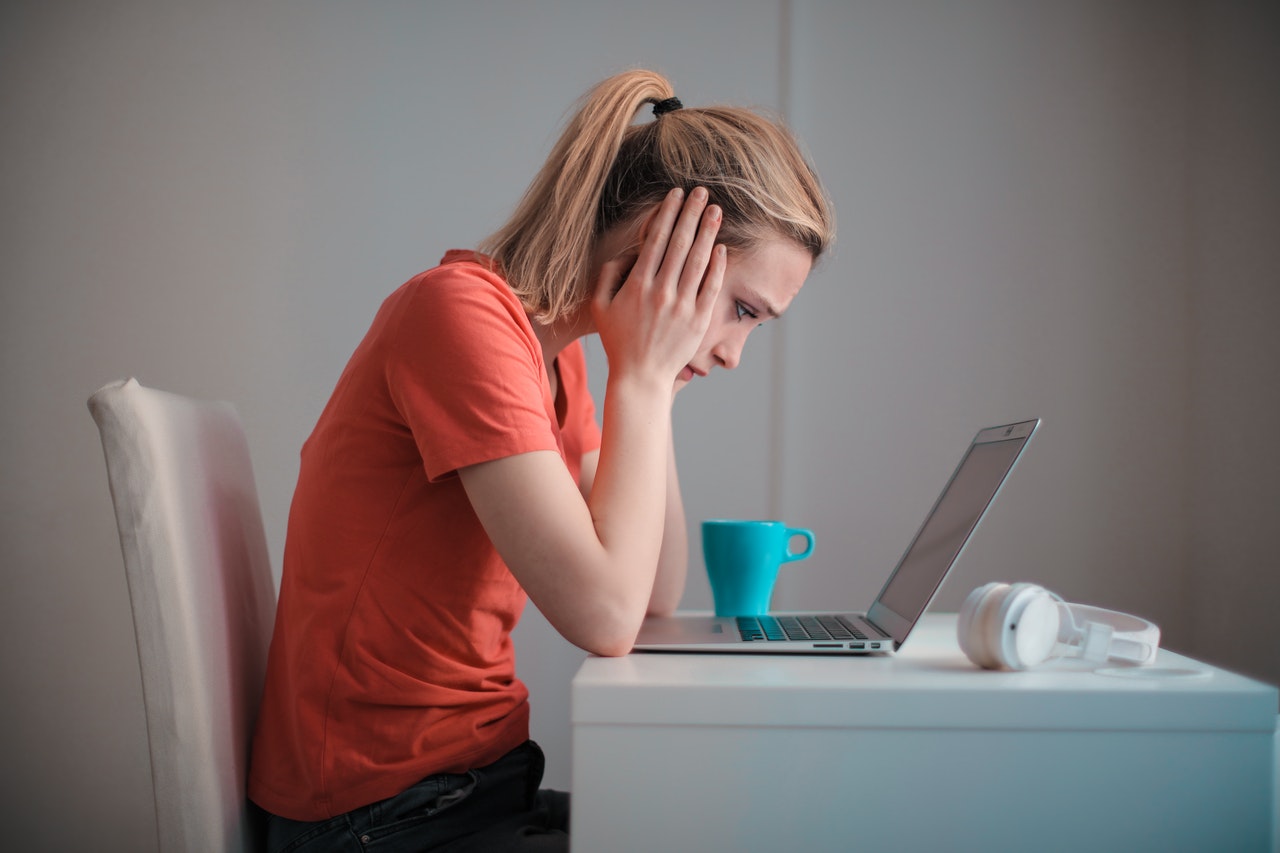 a girl is sitting next to her laptop