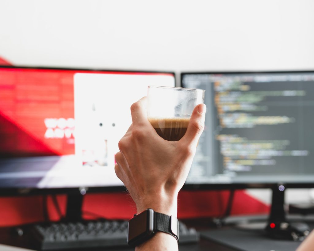 a monitor and a coffee cup