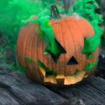 carved pumpkin in a green smoke
